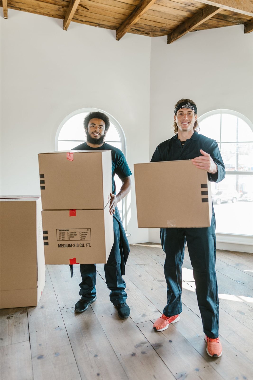 Räumteam trägt Kartons durch eine helle Wohnung